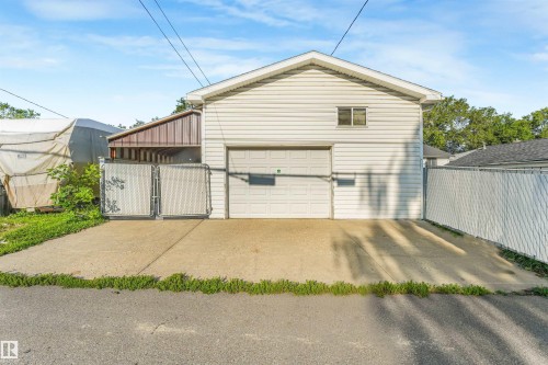 Two-story garage structure with white horizontal siding and a single garage door - 12209 94 Street Nw, Edmonton, AB - Outdoor