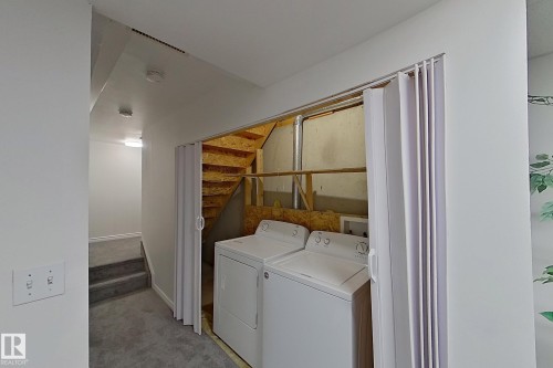 Laundry area with bi-fold door entry and a full-size washer and dryer - #7 16823 84 St Nw Nw, Edmonton, AB - Indoor Photo Showing Laundry Room