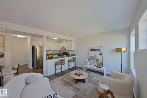 Kitchen with white cabinetry, stainless steel appliances, and a breakfast bar - #7 16823 84 St Nw Nw, Edmonton, AB - Indoor
