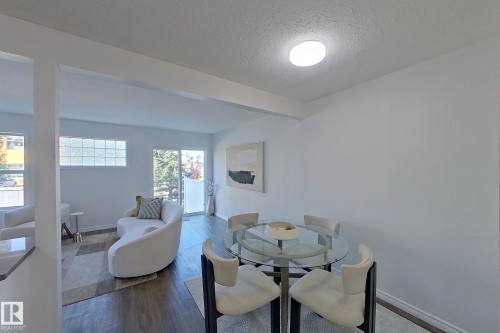 Wood-finish flooring throughout, with a sliding glass door and transom window - #7 16823 84 St Nw Nw, Edmonton, AB - Indoor