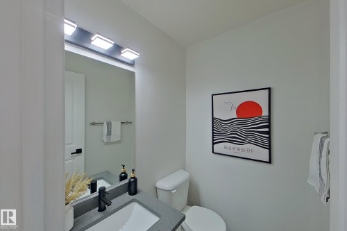 Integrated vanity with a gray countertop and undermount sink, complemented by a matte black faucet - #7 16823 84 St Nw Nw, Edmonton, AB - Indoor Photo Showing Bathroom