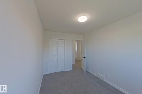 Neutral wall paint, carpet flooring, bi-fold closet doors, and recessed ceiling light fixture - #7 16823 84 St Nw Nw, Edmonton, AB - Indoor Photo Showing Other Room