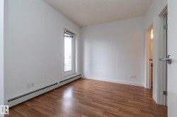 Wood-finish flooring, white walls, and a large window with white trim - 