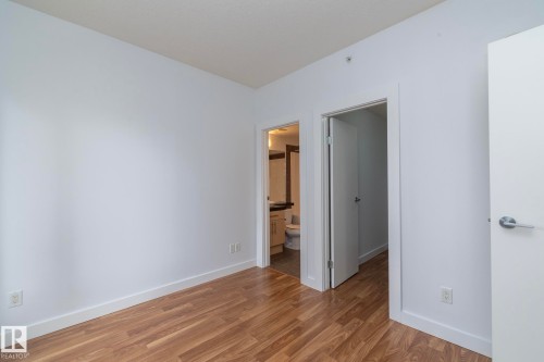 Wood-finish flooring with white baseboards - #1004 10136 104 St Nw, Edmonton, AB - Indoor Photo Showing Other Room