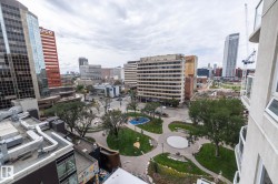 Urban skyline with varied architectural styles, including contemporary glass-fronted buildings and a park with walking paths - 