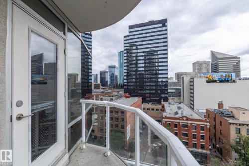 Private balcony with glass panel railing and cityscape backdrop - #1004 10136 104 St Nw, Edmonton, AB - Outdoor With Balcony