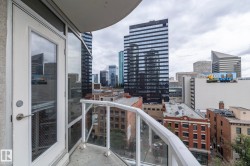Private balcony with glass panel railing and cityscape backdrop - 