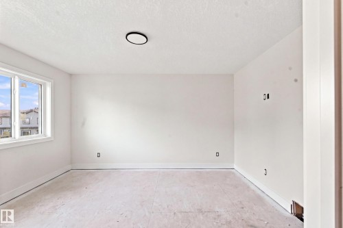 Recessed lighting fixture, unfinished flooring, white walls, and a window with white trim - 1818 155 Avenue Nw, Edmonton, AB - Indoor Photo Showing Other Room