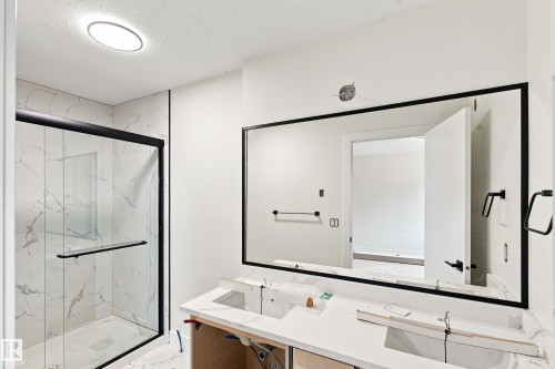 Walk-in shower with clear glass enclosure, matte black frame, and white tile surround - 1818 155 Avenue Nw, Edmonton, AB - Indoor Photo Showing Bathroom