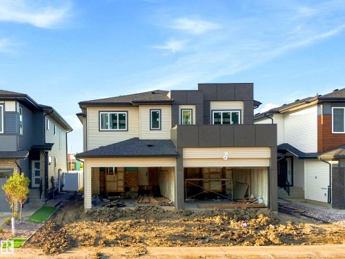 Modern exterior featuring multiple cladding materials, dark-framed windows, and an attached garage structure - 1818 155 Avenue Nw, Edmonton, AB - Outdoor