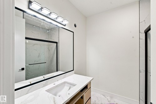 Vanity with integrated sink, stone-finish countertop, and wood-finish cabinetry - 1818 155 Avenue Nw, Edmonton, AB - Indoor Photo Showing Other Room