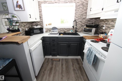 5404 52 Street, Clyde, AB - Indoor Photo Showing Kitchen With Fireplace
