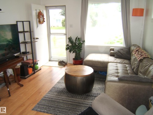 Living area featuring light wood-finish flooring and a large window - 5530 50 Street, Vegreville, AB 