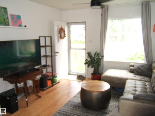 Living area with wood-finish flooring and a ceiling fan - 5530 50 Street, Vegreville, AB 