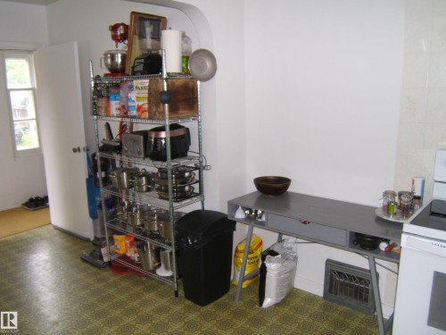 Kitchen area featuring patterned floor tiles, white walls, and an arched doorway - 5530 50 Street, Vegreville, AB 