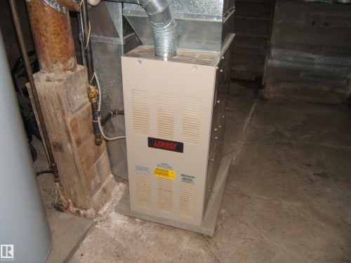 Lennox furnace installed on a concrete pad with galvanized ductwork - 5530 50 Street, Vegreville, AB 