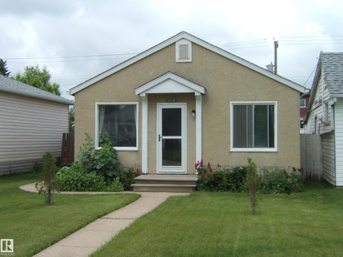 Stucco exterior featuring a covered entry porch - 5530 50 Street, Vegreville, AB 