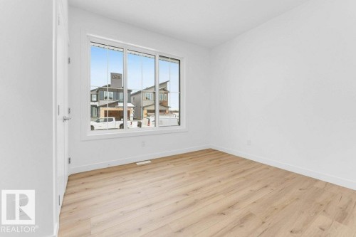 Wood-finish flooring, white walls, and a multi-pane window with white trim - 182 Pacific Drive, Spruce Grove, AB - Indoor Photo Showing Other Room