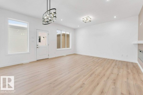 Light wood-finish flooring with white walls and trim, featuring multiple windows - 182 Pacific Drive, Spruce Grove, AB - Indoor Photo Showing Other Room