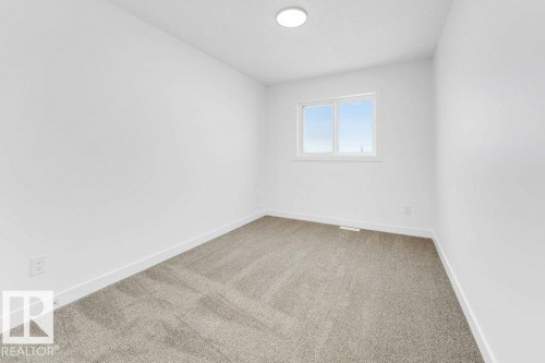 Neutral-toned carpeting, white walls, and a ceiling-mounted light fixture - 182 Pacific Drive, Spruce Grove, AB - Indoor Photo Showing Other Room