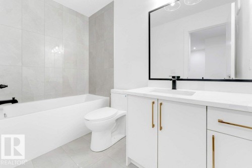 White vanity with gold-finish hardware, built-in sink, and matte black faucet - 182 Pacific Drive, Spruce Grove, AB - Indoor Photo Showing Bathroom