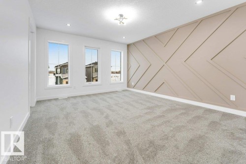 Textured accent wall, recessed lighting, neutral carpeting, modern flush mount light fixture, multiple windows - 182 Pacific Drive, Spruce Grove, AB - Indoor Photo Showing Other Room