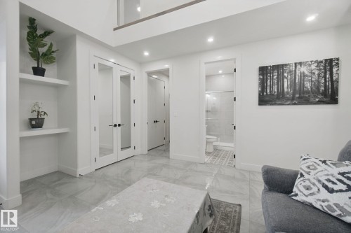 Recessed wall shelving, glass panel double doors, and wood-finish flooring - 4820 174 Avenue Nw, Edmonton, AB - Indoor Photo Showing Other Room
