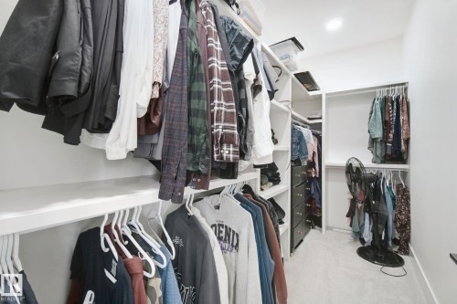 Custom closet system featuring built-in shelving, multiple hanging rods, and integrated drawer storage - 4820 174 Avenue Nw, Edmonton, AB - Indoor With Storage