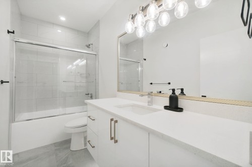 Spacious vanity with integrated sink and chrome faucet - 4820 174 Avenue Nw, Edmonton, AB - Indoor Photo Showing Bathroom
