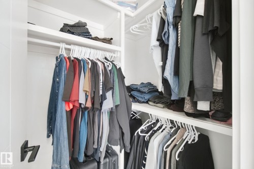 Built-in closet shelving system featuring multiple hanging rods and integrated storage - 4820 174 Avenue Nw, Edmonton, AB - Indoor With Storage
