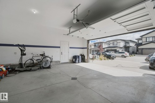 Spacious garage with concrete flooring, overhead lighting, and an automatic garage door opener - 4820 174 Avenue Nw, Edmonton, AB - Indoor Photo Showing Garage