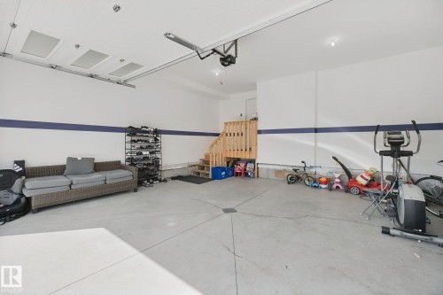 Concrete flooring, interior wood staircase, white walls, and overhead lighting - 4820 174 Avenue Nw, Edmonton, AB - Indoor Photo Showing Garage