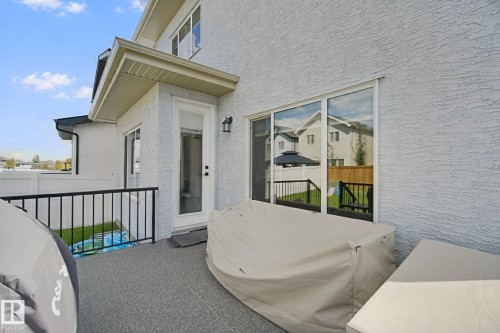Patio featuring a non-slip surface, white exterior siding, and a glass-paneled door - 4820 174 Avenue Nw, Edmonton, AB - Outdoor With Exterior