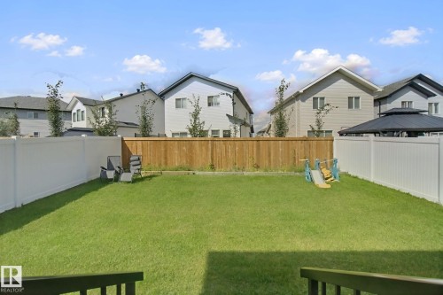 Expansive backyard featuring a lush lawn, white vinyl fencing, and a natural wood privacy fence - 4820 174 Avenue Nw, Edmonton, AB - Outdoor With Backyard