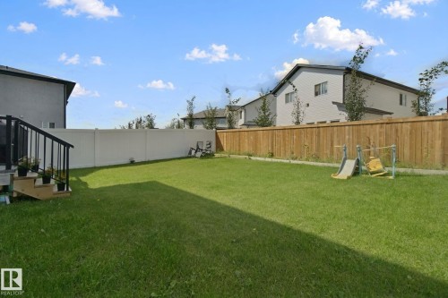 Expansive grass lawn with a wood privacy fence and a white vinyl privacy fence - 4820 174 Avenue Nw, Edmonton, AB - Outdoor With Backyard