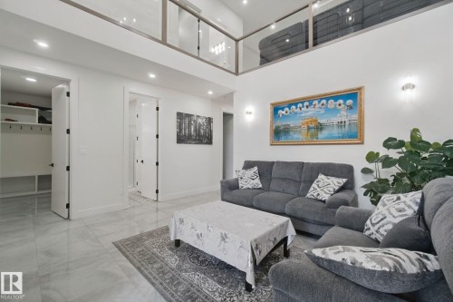 Vaulted ceiling with a mezzanine, recessed lighting, and wall sconces - 4820 174 Avenue Nw, Edmonton, AB - Indoor Photo Showing Living Room
