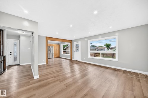 Spacious living area featuring wood-finish flooring, recessed lighting, and light grey wall tones - 7603 130 Avenue Nw, Edmonton, AB - Indoor Photo Showing Living Room