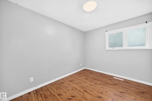 Wood-finish flooring, light gray wall tones, and a flush-mount ceiling light - 7603 130 Avenue Nw, Edmonton, AB - Indoor Photo Showing Other Room