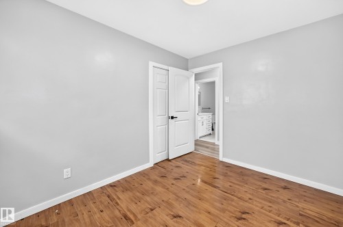 Wood-finish flooring, light grey walls, and a white interior door - 7603 130 Avenue Nw, Edmonton, AB - Indoor Photo Showing Other Room