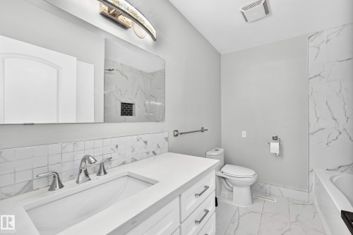 White vanity with polished chrome hardware, integrated sink, and white countertop - 7603 130 Avenue Nw, Edmonton, AB - Indoor Photo Showing Bathroom