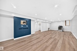 Recessed lighting, wood-finish flooring, built-in wall feature, stainless steel range, and light gray wall paint - 