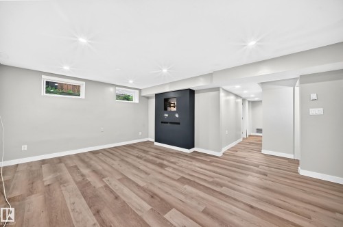 Spacious room featuring wood-finish flooring, recessed lighting, and light gray walls - 7603 130 Avenue Nw, Edmonton, AB - Indoor