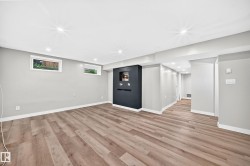 Spacious room featuring wood-finish flooring, recessed lighting, and light gray walls - 