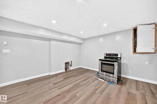 Recessed lighting, wood-finish flooring, light gray wall color, white trim, stainless steel electric range - 7603 130 Avenue Nw, Edmonton, AB - Indoor