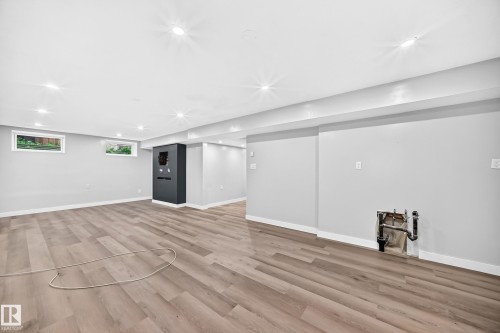 Recessed lighting illuminates the expansive space featuring wood-finish flooring, light grey walls, and white trim - 7603 130 Avenue Nw, Edmonton, AB - Indoor
