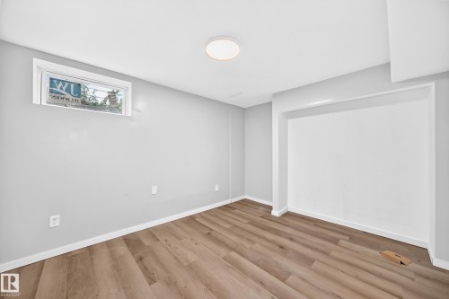 Recessed wall alcove, wood-finish flooring, white trim, single window, and a flush-mount ceiling light - 7603 130 Avenue Nw, Edmonton, AB - Indoor Photo Showing Other Room