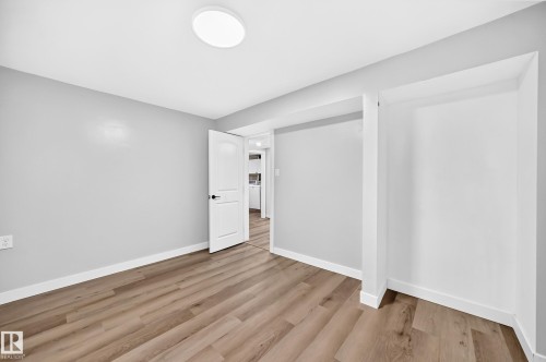 Wood-finish flooring, light gray wall paint, and recessed ceiling lighting - 7603 130 Avenue Nw, Edmonton, AB - Indoor Photo Showing Other Room