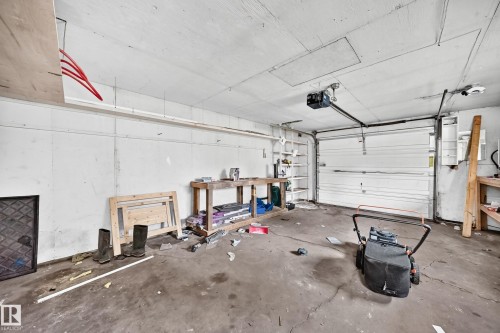 Garage space with concrete flooring, automatic garage door opener, and integrated shelving - 7603 130 Avenue Nw, Edmonton, AB - Indoor Photo Showing Garage