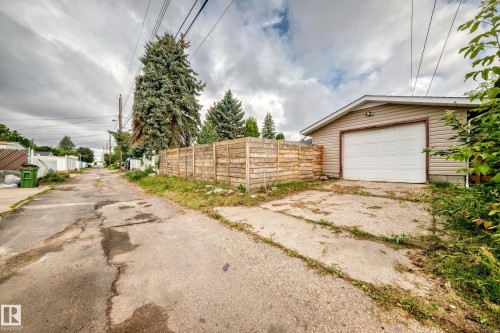 Detached garage with horizontal siding, white garage door, and exterior light fixture - 7603 130 Avenue Nw, Edmonton, AB - Outdoor