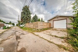 Detached garage with horizontal siding, white garage door, and exterior light fixture - 